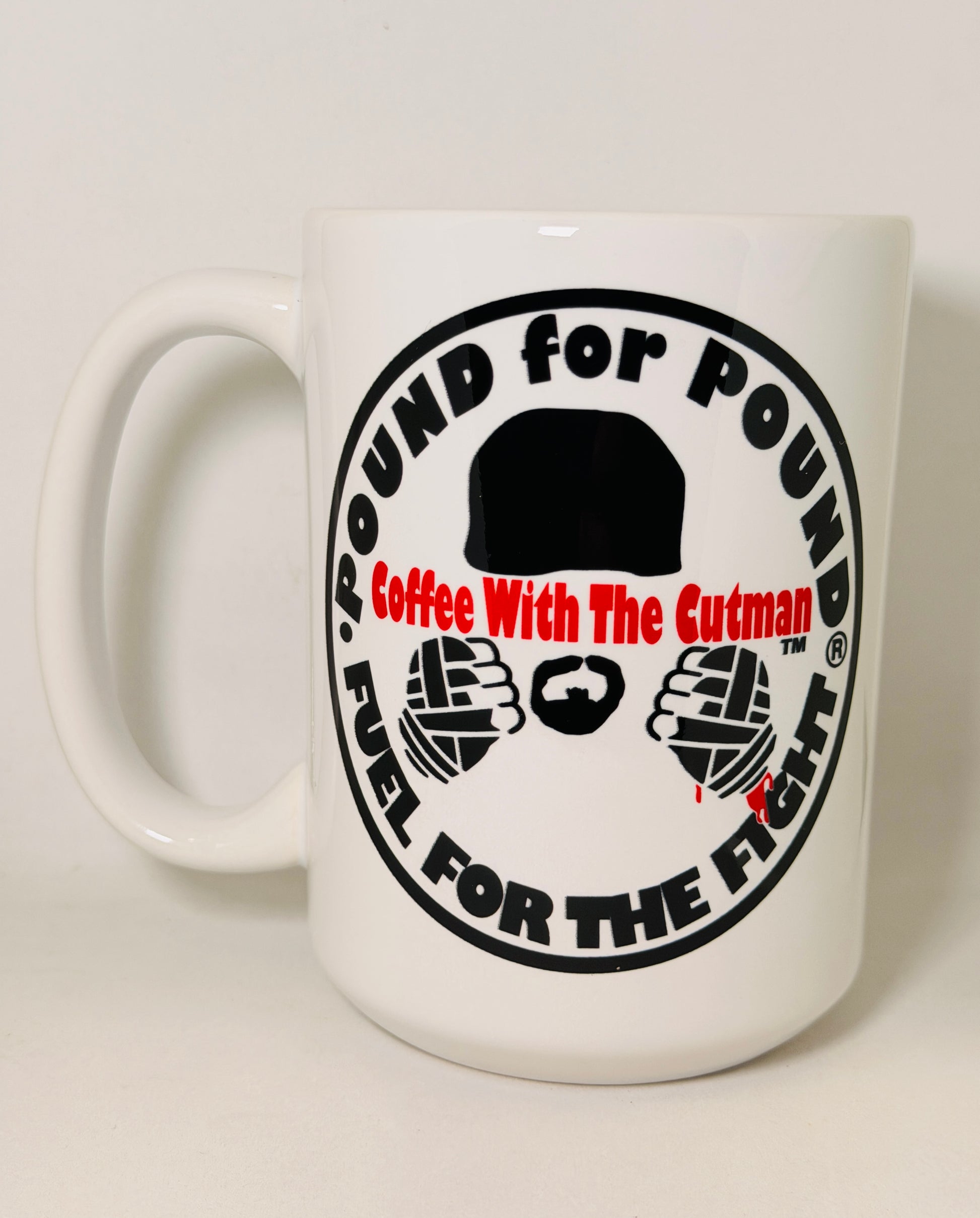 A white ceramic coffee mug featuring a circular black and red graphic design with the text 'POUND FOR POUND Coffee With The Cutman FUEL FOR THE FIGHT' and illustrations of a hat, beard, and fists.